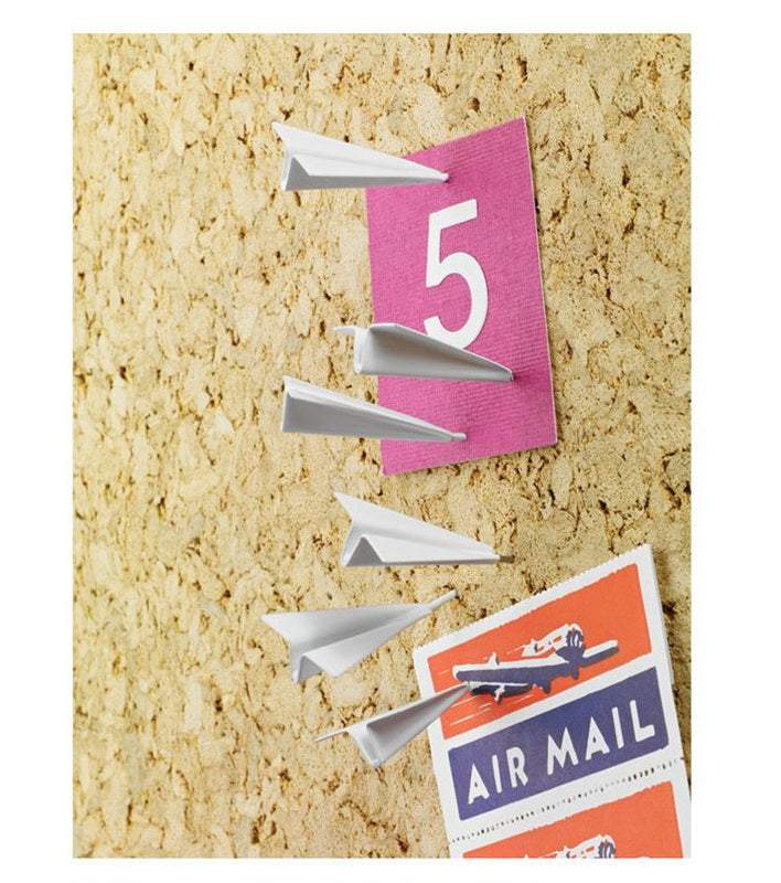 Paper airplane design pins on a bulletin board