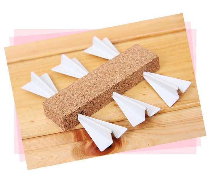 Paper airplane design pins on a bulletin board